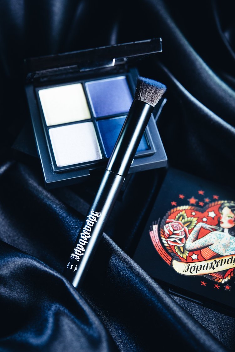 An image of a makeup brush and palette on a black cloth, highlighting cosmetics photography.jpg