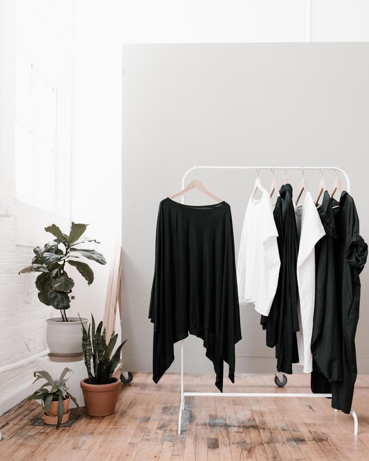 Brand's product photography featuring black shirts hanging on a white rack.jpg