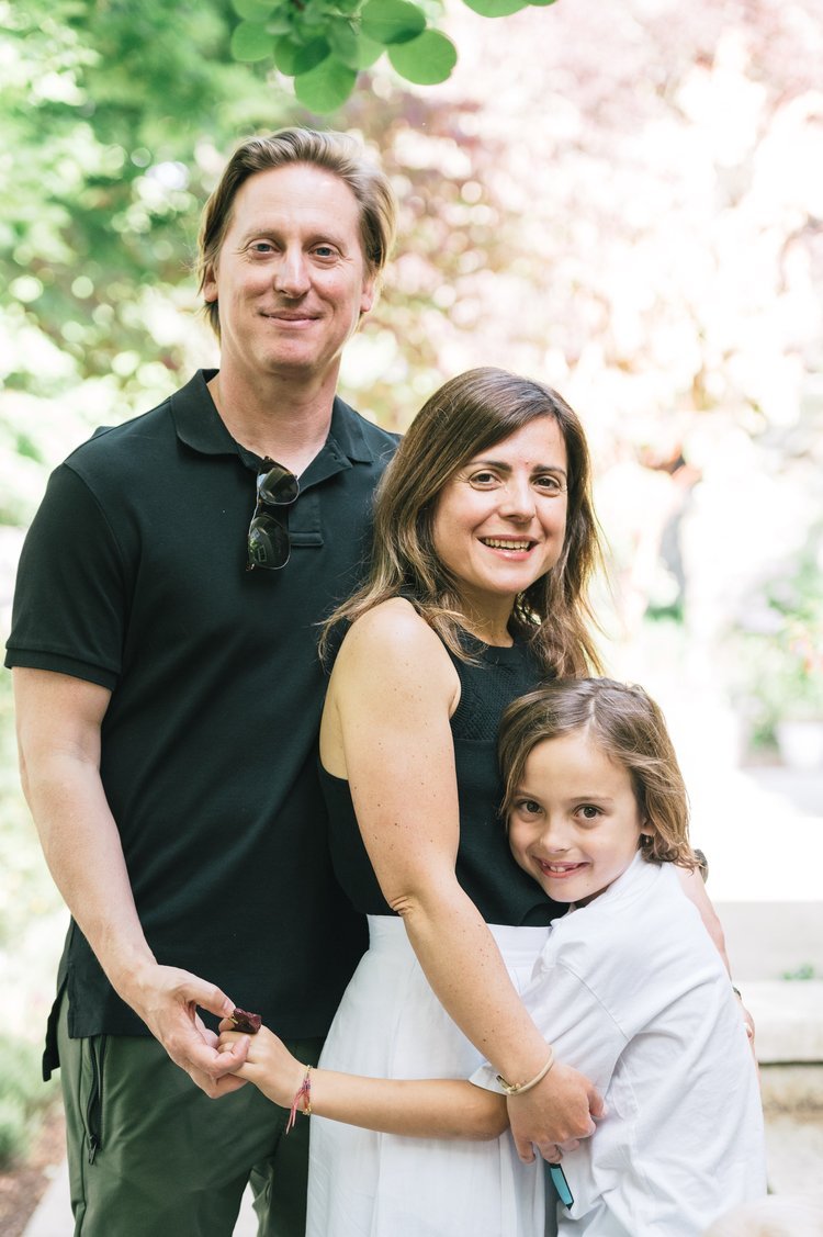 A family smiling and posing for a photo in the park during a family portrait session.jpg