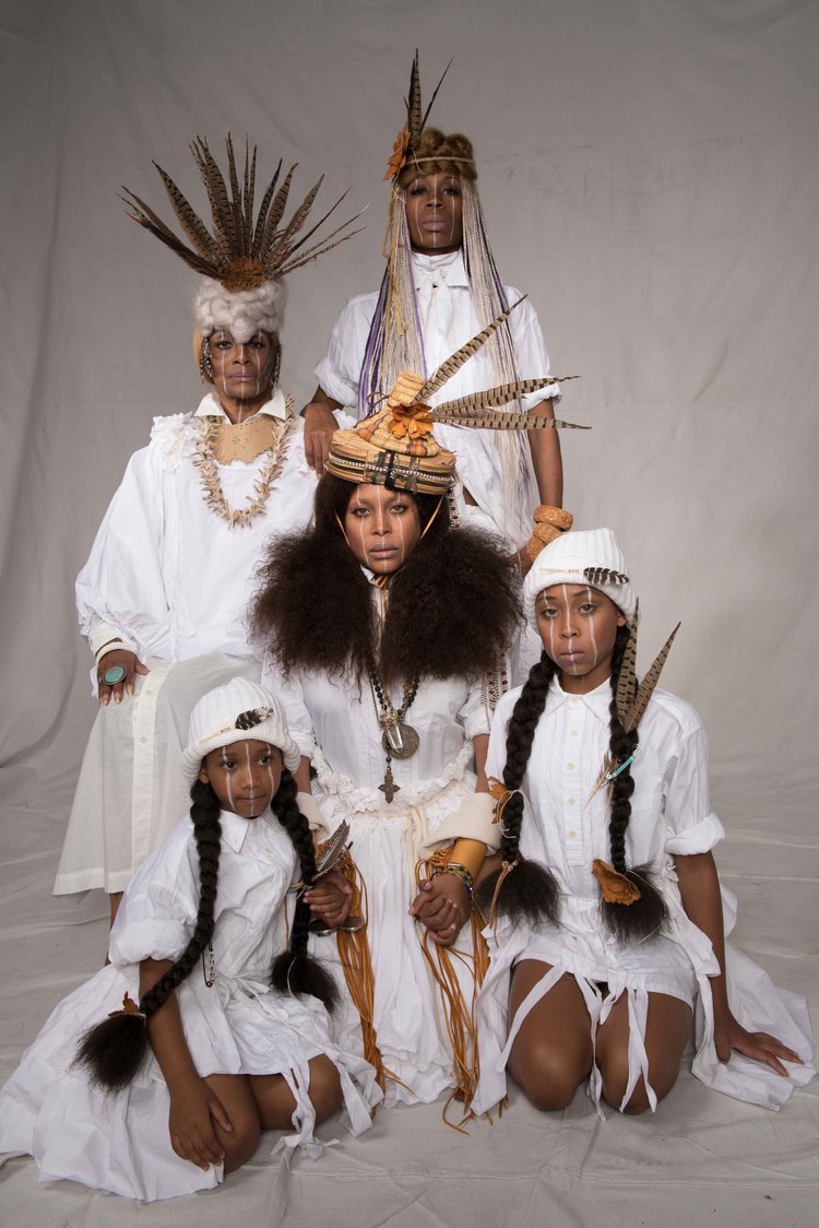 A tribe’s family traditionally dressed in white poses for a photo, capturing a moment of togetherness and joy.jpg