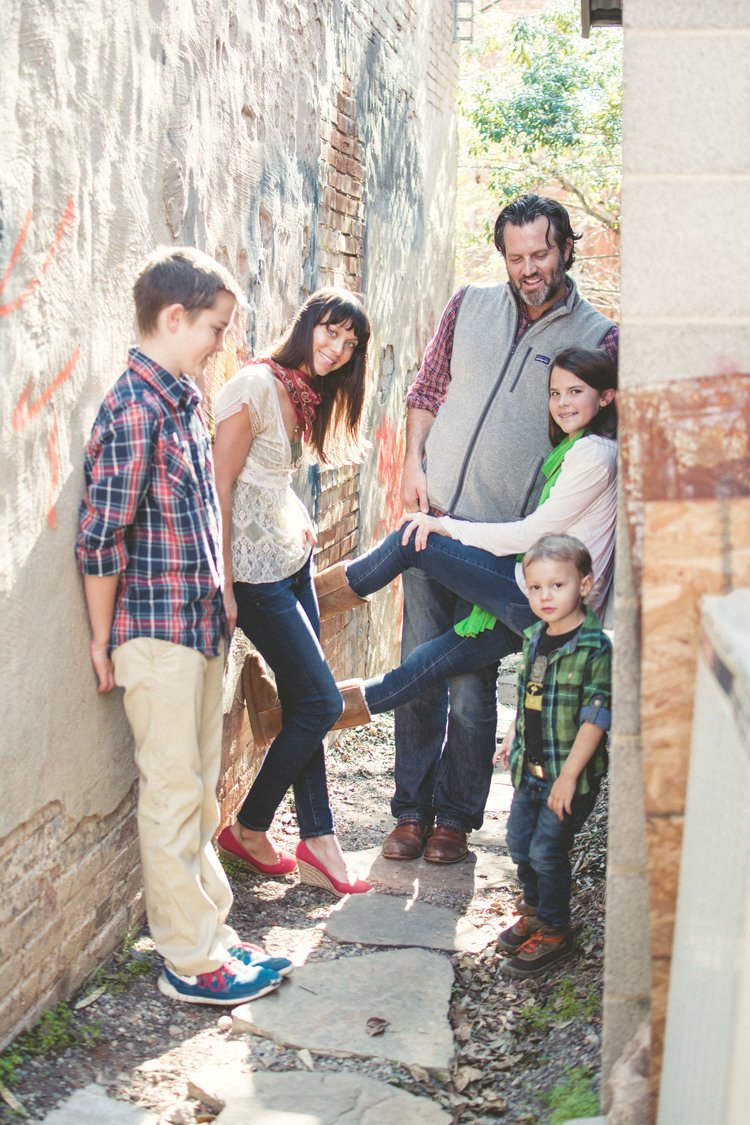 In an alleyway, a family gathers for a photo, showcasing their bond and shared happiness.jpg