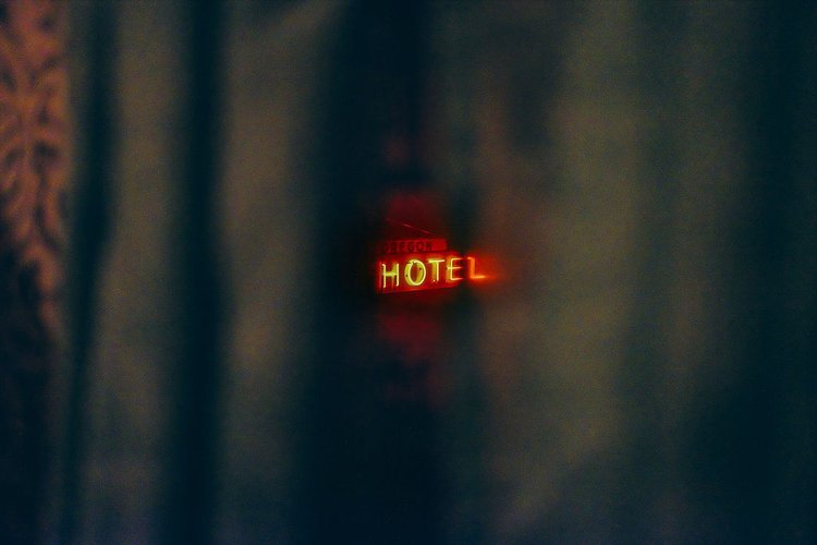 A hotel sign peeks through a curtain, captured by a destination photographer in Portland, Oregon.jpg