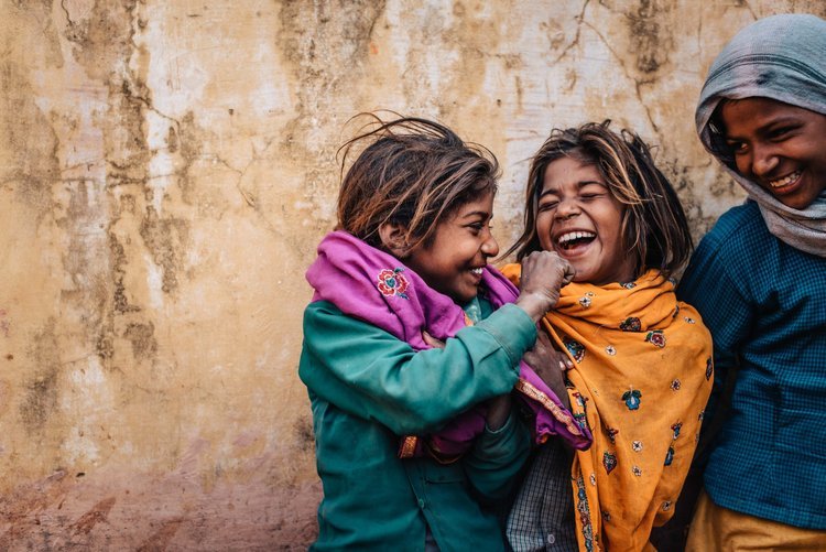A professional Portland travel photographer is capturing some happy children posing for the camera in India..jpg
