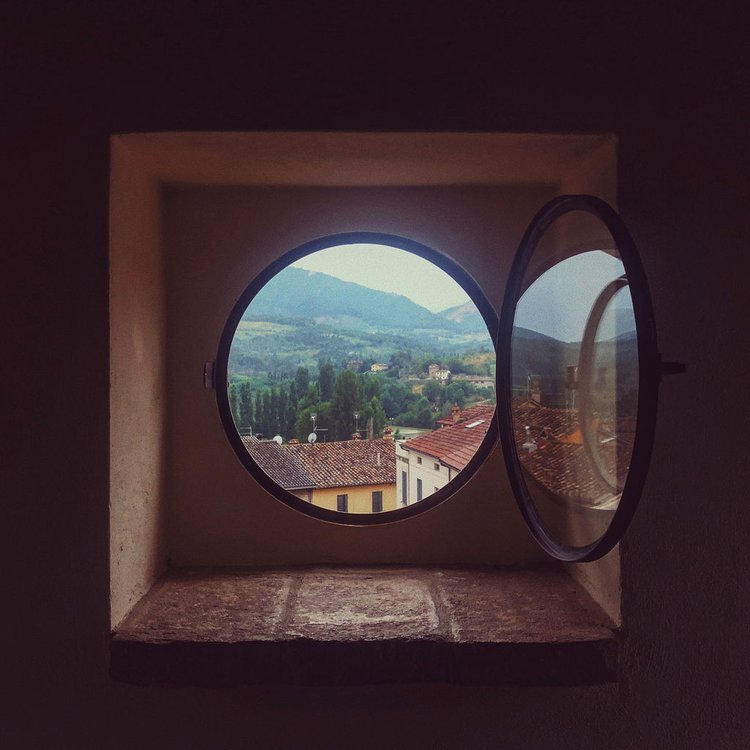 A round window showcasing a breathtaking mountain view, captured by a travel photographer from Portland..jpg