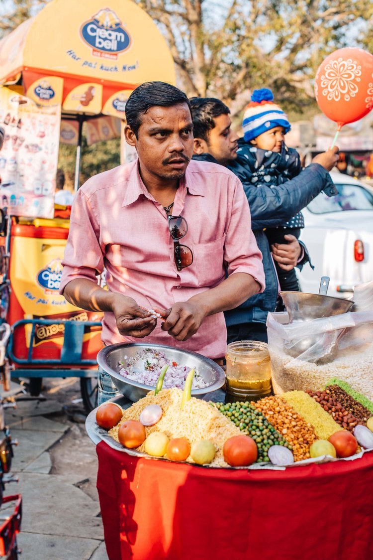 A street vendor in India selling food at a bustling market fascinated travel photographer of Portland to capture a photo.jpg