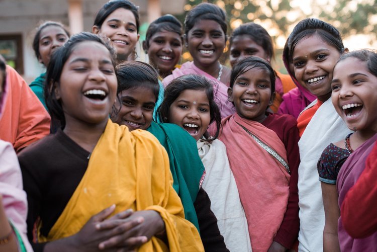 A vibrant group of women in colorful traditional saris smiling, captured by the best destination photographer from Portland in Asia.jpg