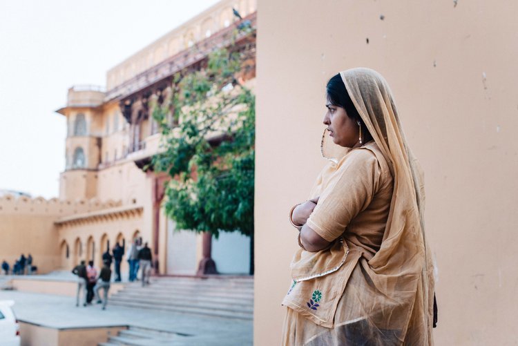 Indian woman in traditional sari poses outside building, captured by Portland travel photographer.jpg