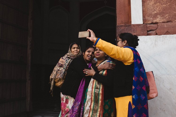 Portland photographer captures three women taking a selfie in front of a building while traveling in India..jpg