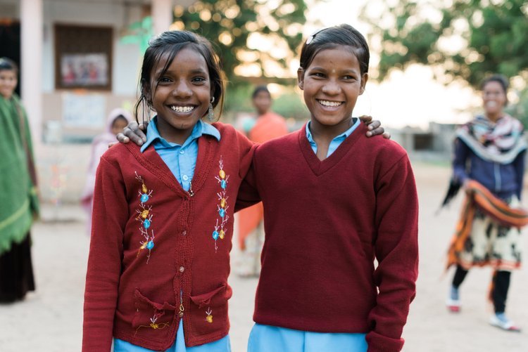 Two young girls in school uniforms standing together, captured by the best travel photographer in Portland, Oregon, during their visit to the Sub-continent.jpg