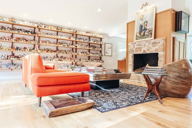 Living room with fireplace and shelves full of figurines. Captured by a top interior design photographer.jpg