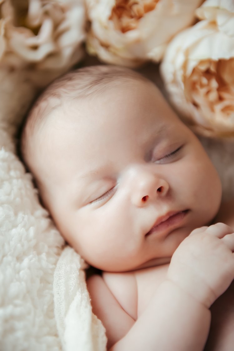 A peacefully sleeping newborn baby with closed eyes captured through lens of Patrizia a portland children photographer.jpg
