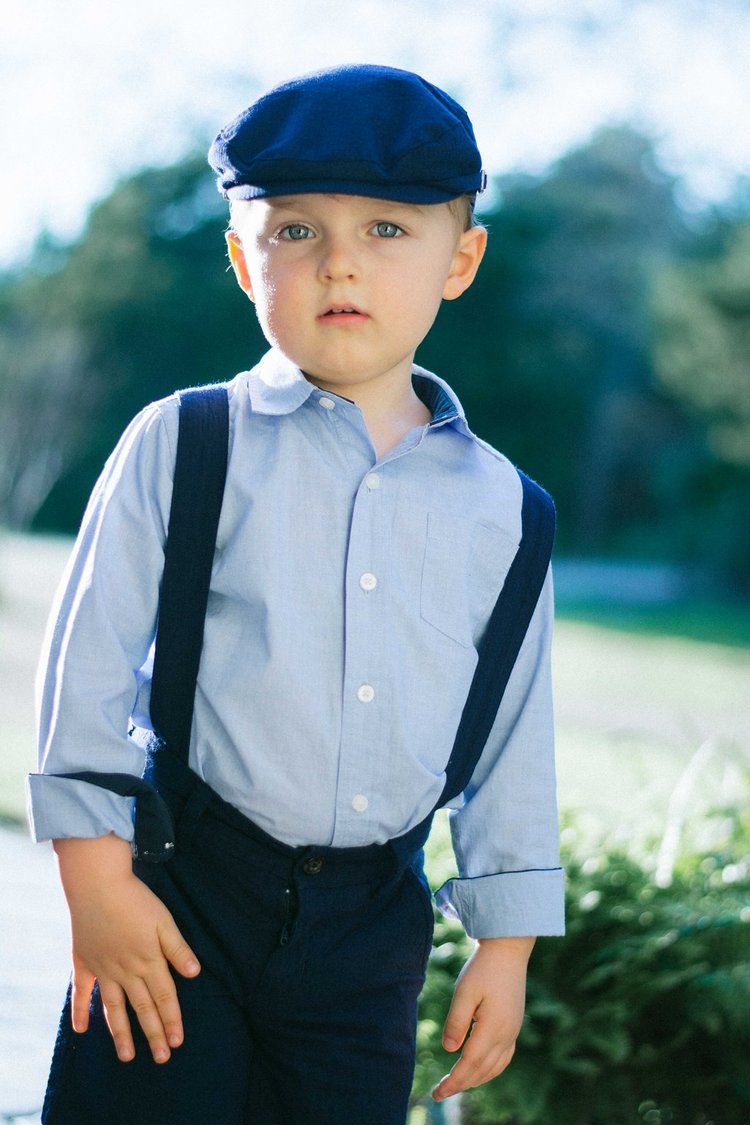 A young boy with suspenders and a hat poses for a children's portrait photography in Portland, Oregon.jpg