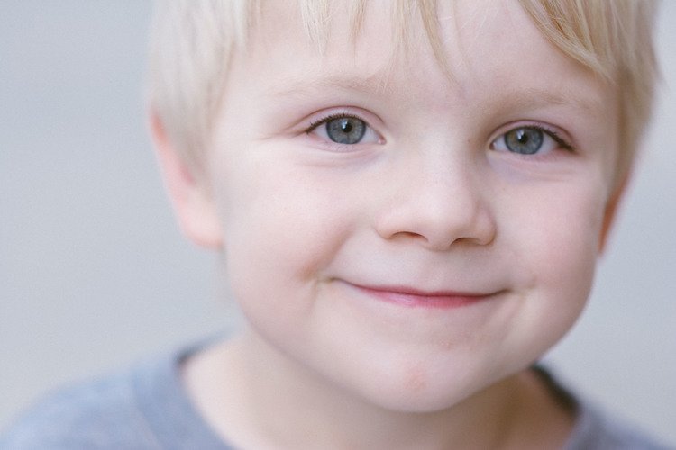An image of a young boy with blonde hair and blue eyes, taken in the realm of children's portrait photography.jpg