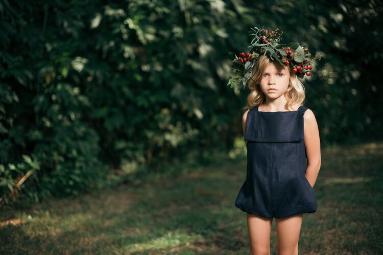 An innocent little girl adorned with a berry wreath on her head, emanating pure joy..jpg