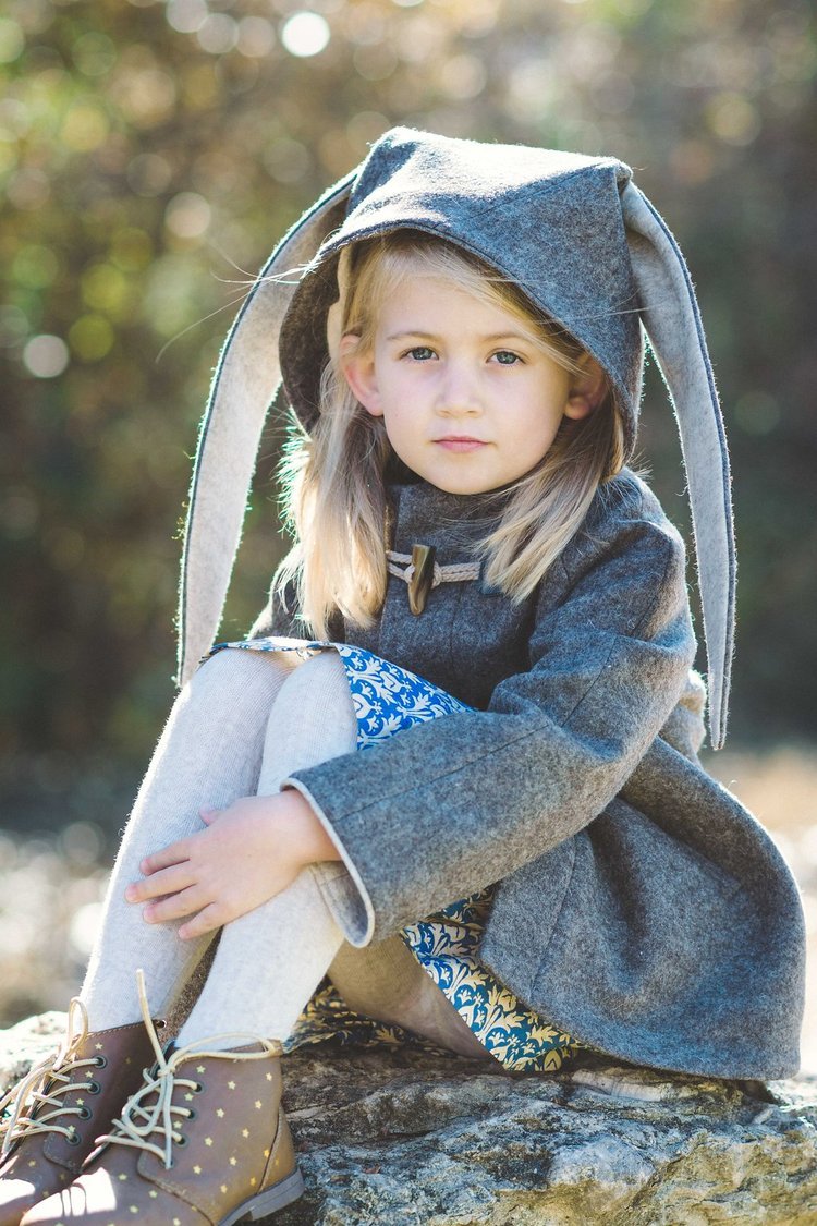 Portrait of a little girl in a grey coat and bunny ears, captured by a children photographer.jpg