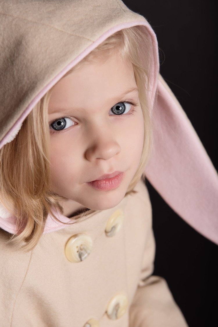 The best children photographer in Portland captures a young girl in a pink coat and bunny hood.jpg