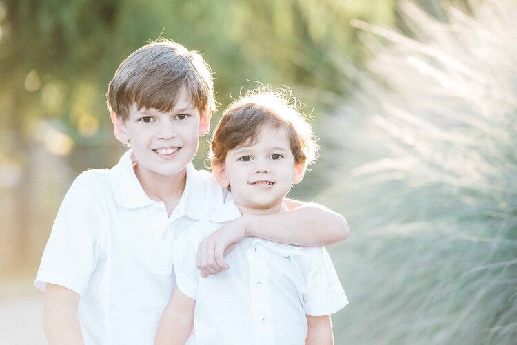 Two little brothers smiling towards the camera for a children's photograph.jpg