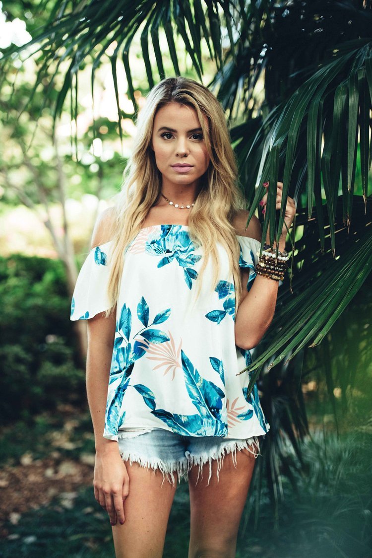 An attractive blonde woman donning a vibrant tropical ensemble, exuding elegance and charm in this lifestyle image.jpg