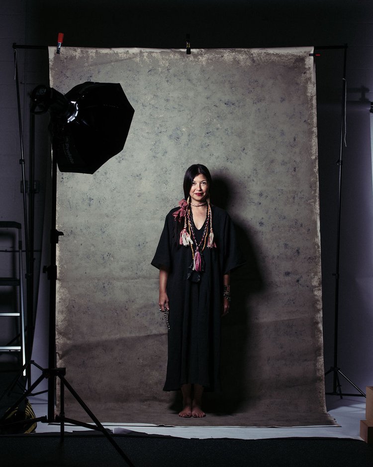 a woman in a black dress standing in front of a camera for indoor editorial photography.jpg