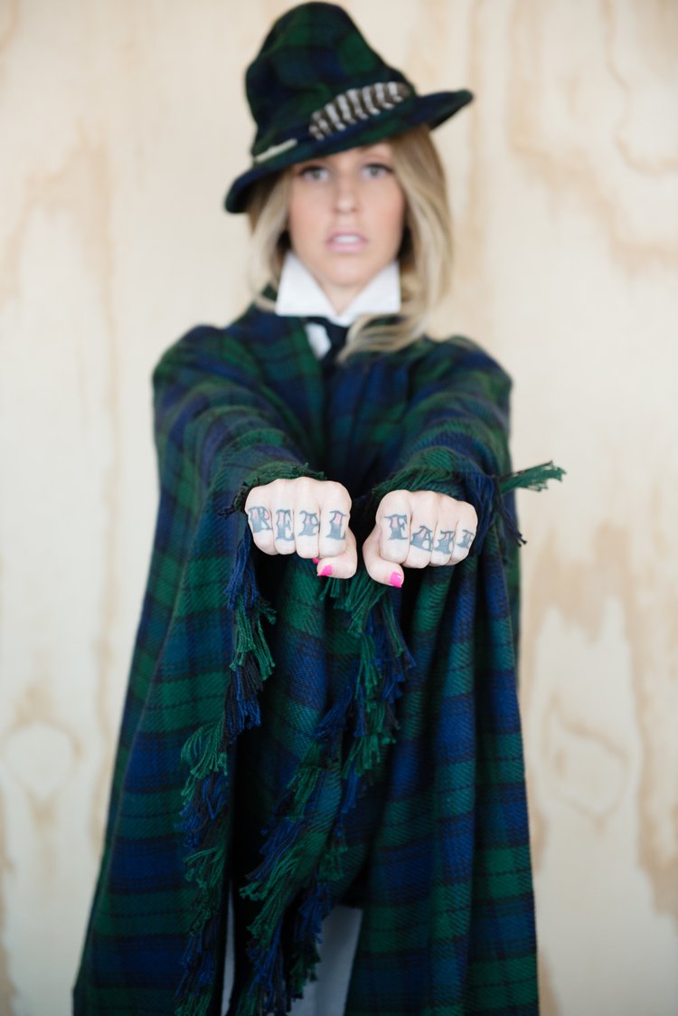A woman in a fashion-forward green and black coat and hat, captured in an editorial-style photograph..jpg
