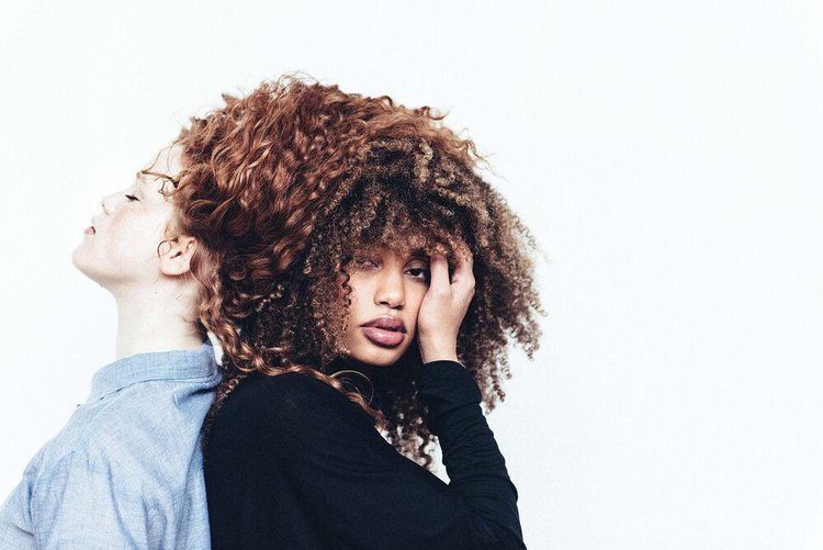 Two curly-haired women posing together for an editorial photographer.jpg