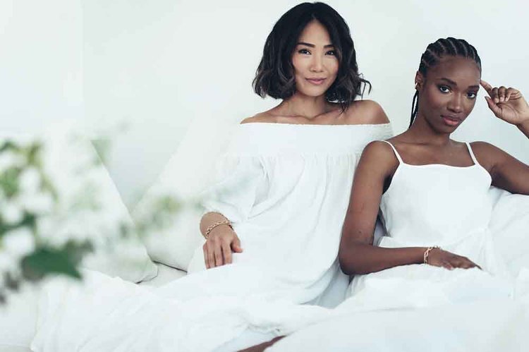two women posing on a white bed in editorial studio in Portland.jpg