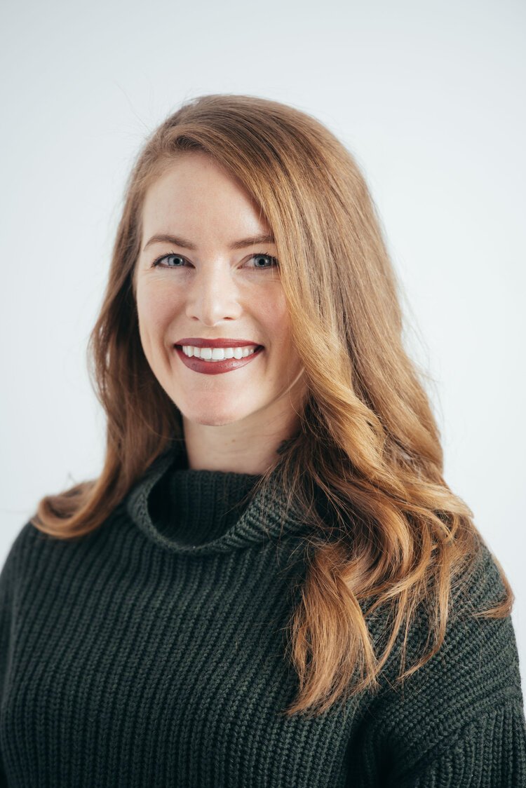 a business headshot of a woman in a green turtleneck sweater.jpg