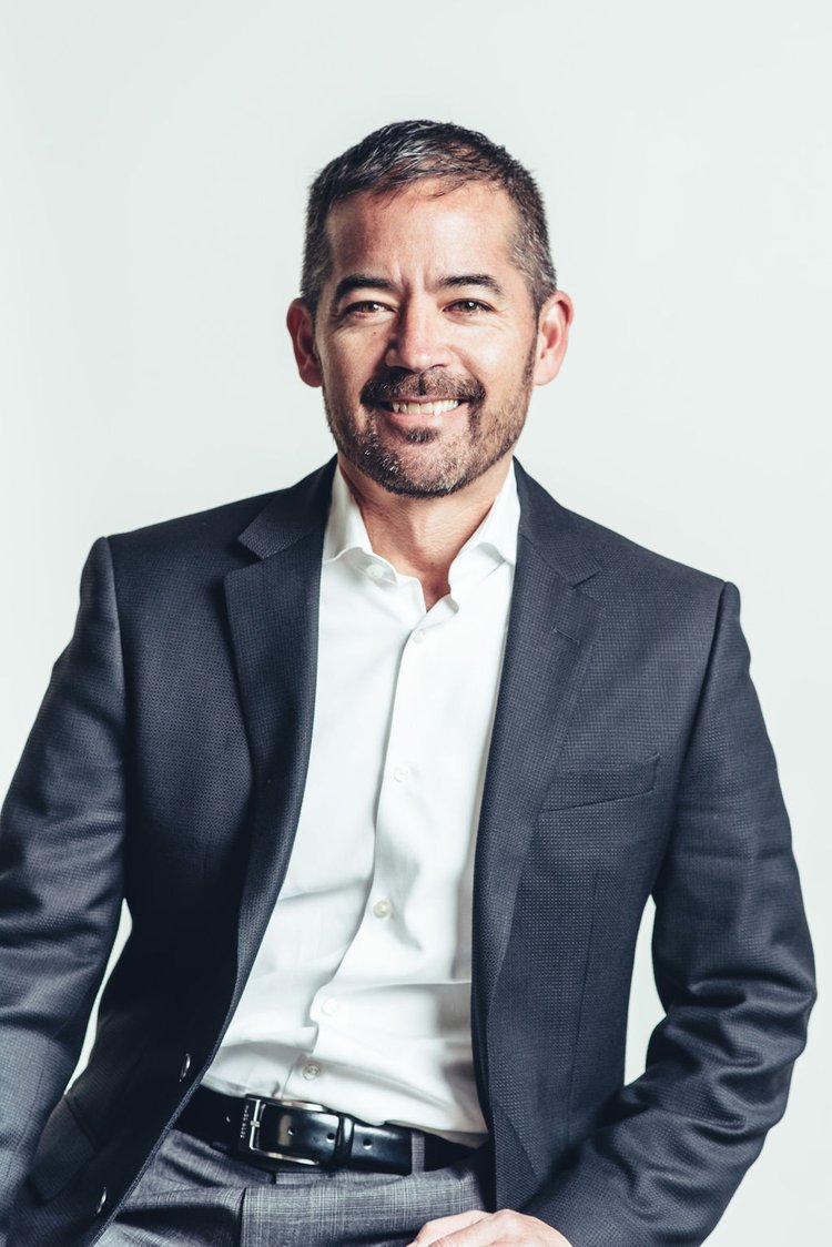 a businessman in a suit happily posing for a business headshot photo.jpg