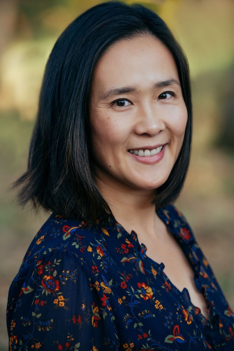 A headshot of a smiling Asian woman in a floral top, taken in Portland.jpg
