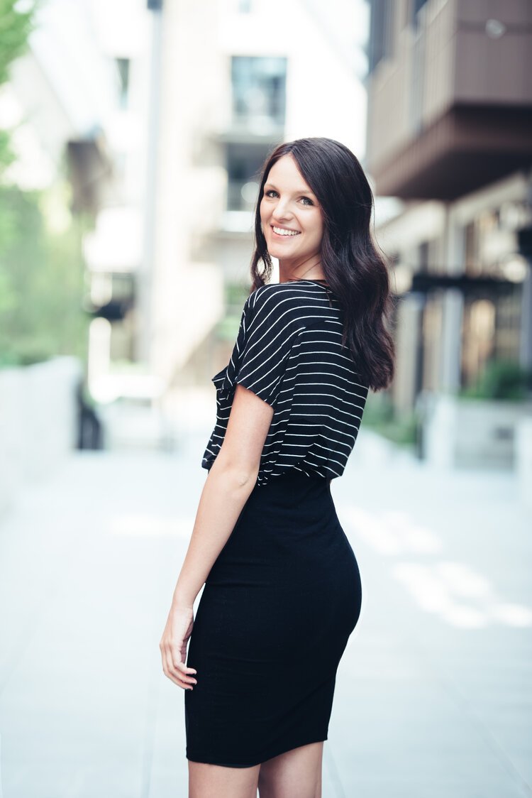 A Portland headshot photographer captured a woman in a black skirt standing on a sidewalk.jpg