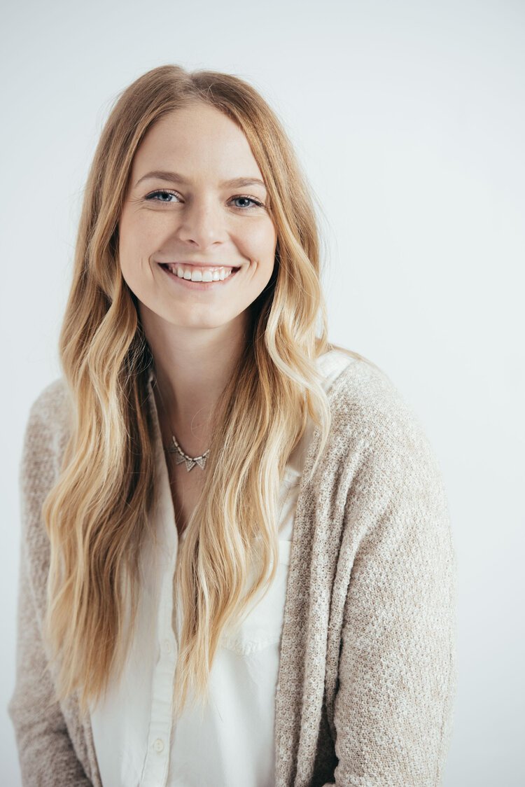 A smiling woman wearing a beige cardigan captured by the best headshot photographer.jpg