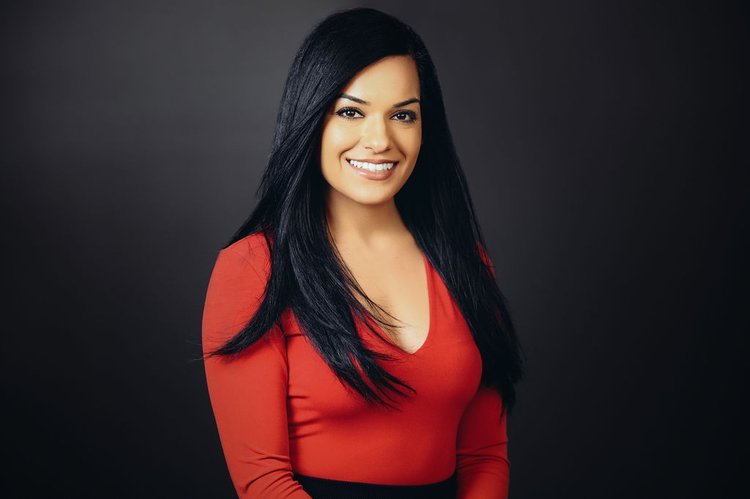 a woman in a red top and black skirt posing for a Portland headshot.jpg