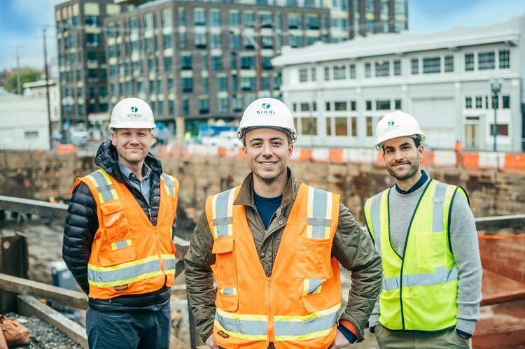 Three professional construction workers posing for headshots in front of a construction site.jpg