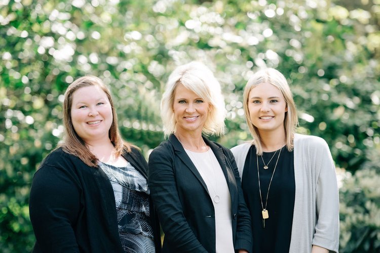 Three women posing for professional headshots in front of bushes in Portland.jpg