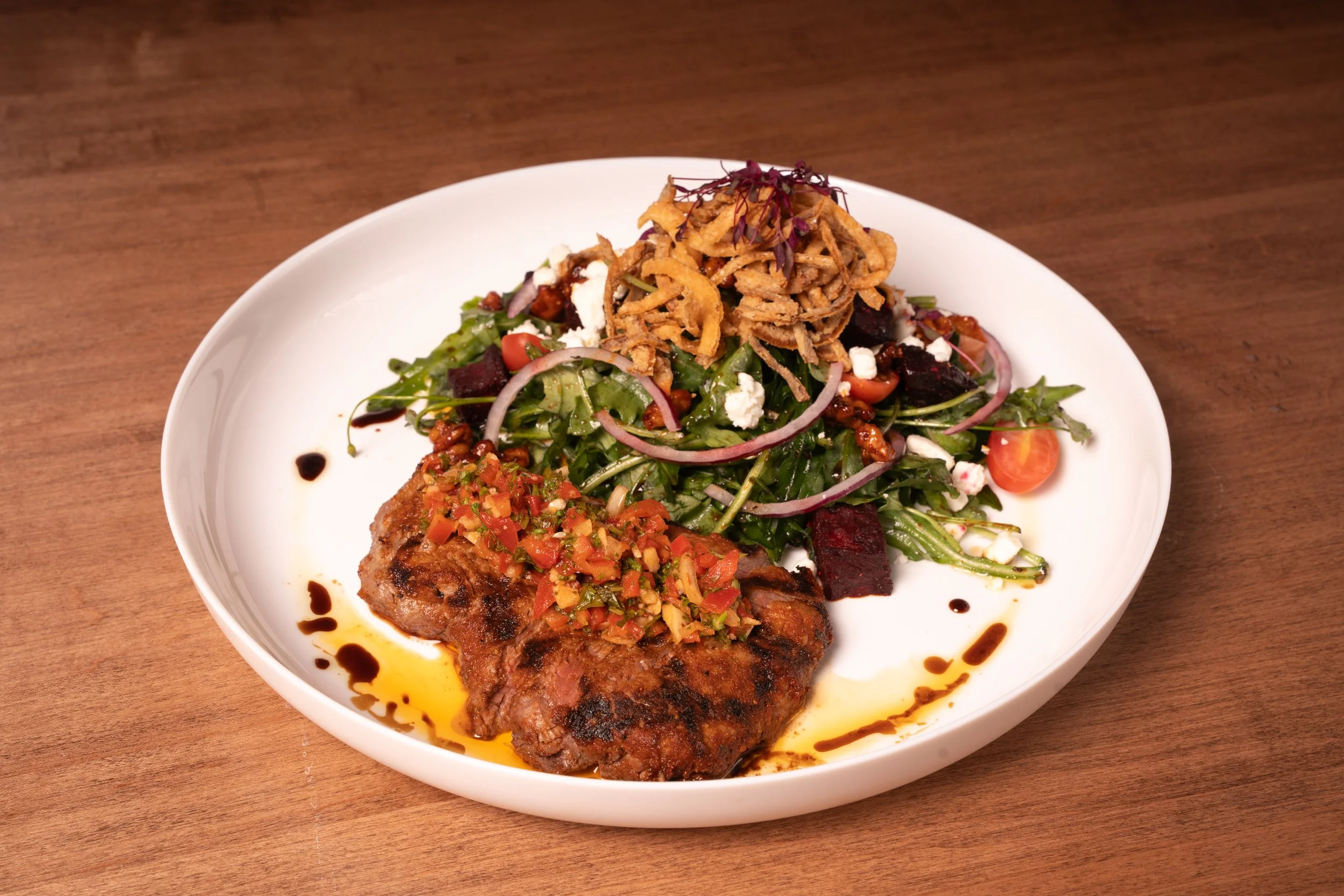 AAA Sirloin Salad (6 oz AAA Alberta sirloin, red chimichurri, baby arugula, roasted beets, grape tomatoes, red onion, candied walnuts, goat cheese, honey balsamic dressing, crispy onion | gluten-free)