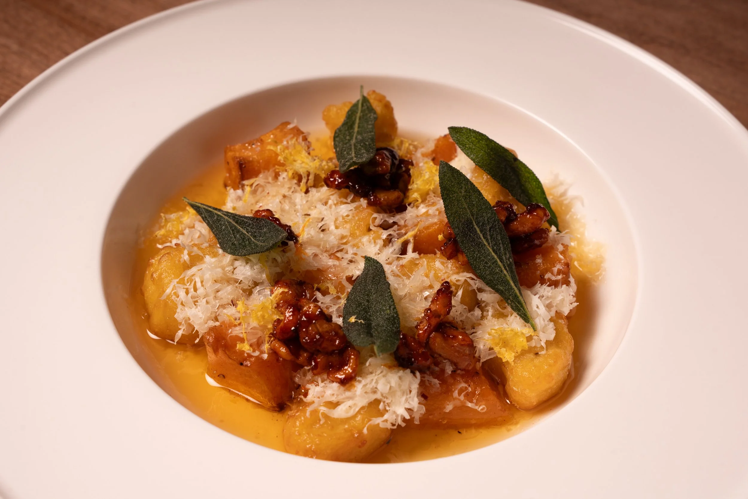 Brown Butter Squash Gnocchi: house rolled squash gnocchi, roasted honey squash, brown butter, candied walnuts, crispy sage, spicy honey, lemon zest, aged parmesan