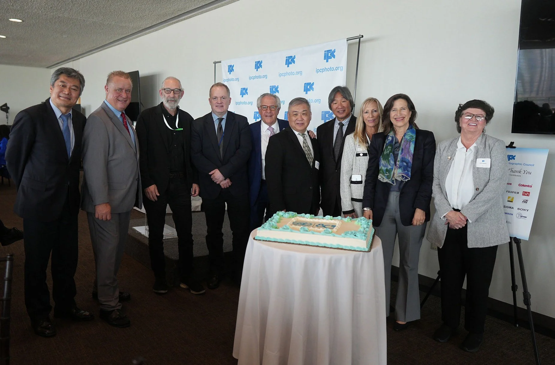  During the 2025 IPC Hall of Fame and Professional Photographer Achievement Awards Luncheon, a cake was presented celebrating 80 years of the United Nations. (pictured left to right) Hak-Fan Lau, Deputy Director, News & Media Division, United Nations; Michael Ayers, IPC VP; Mark Garten, UN Chief Photographer; Ian Phillips, Director News & Media Division, United Nations; Andy Marcus, IPC President; Dr. Mark Chung, IPC VP; Bing Liem, Division President, Imaging Division, FUJIFILM North America Corporation and IPC VP; Kathy Jello, IPC VP; Melissa Fleming, Under-Secretary-General for Global Communications at the United Nations; and Kathy Magrane, IPC VP. 