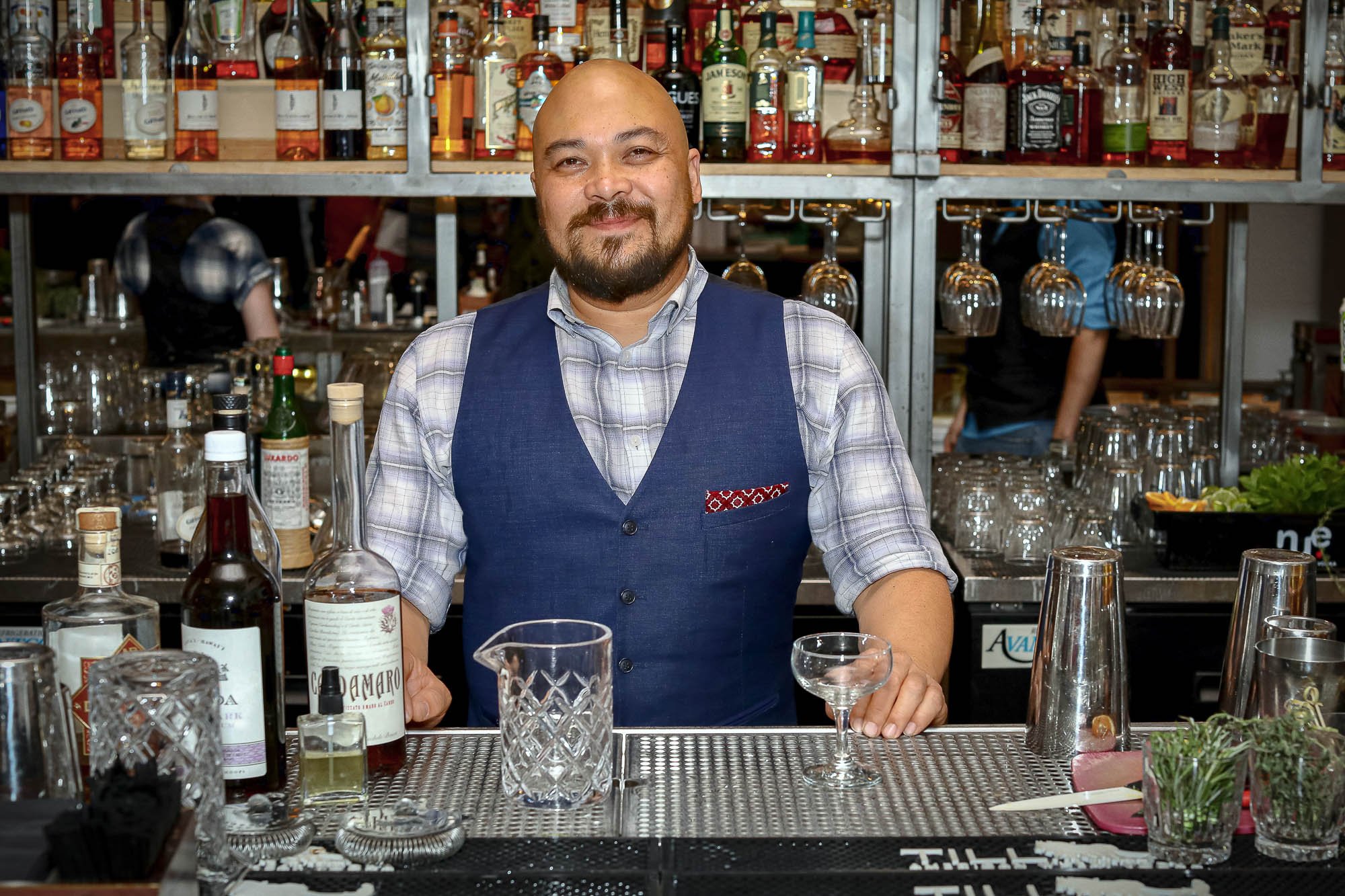 Captured during the NACIA Eating Insects - Hoppy Hour Event at Trust in St. Louis, Missouri, this image features bartender Rob Somerscales crafting his signature insect-flavored rum-based cocktail - The Noisy Cricket. Dressed in a dapper blue vest an