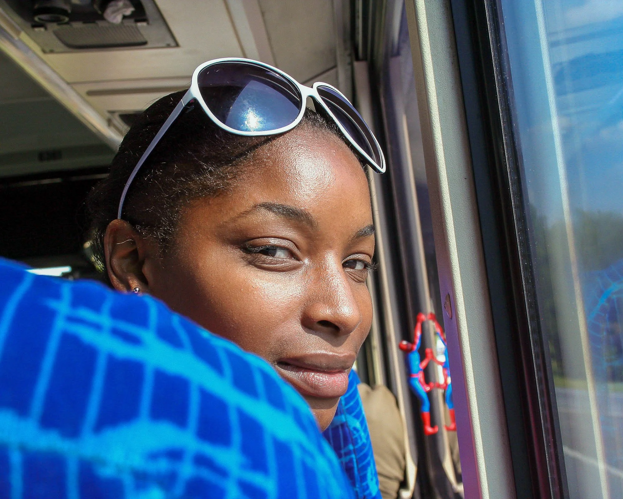 Woman smiling from a seat on a Greyhound bus during a candid travel encounter