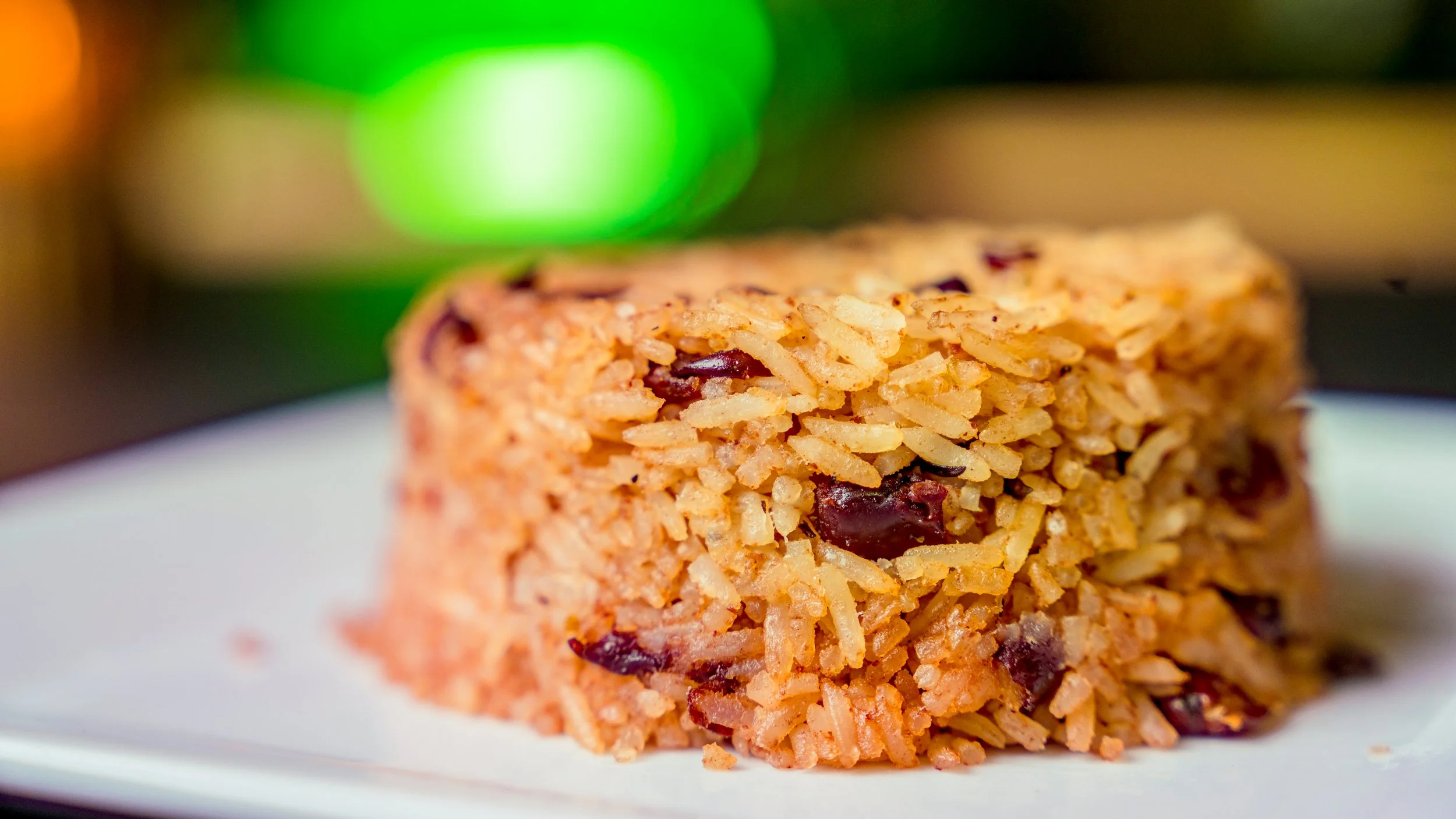 Best professional food photography rice and peas macro on white plate with blurred green yellow backdrop in New York City and shot by Lumumba David from David Media Group
