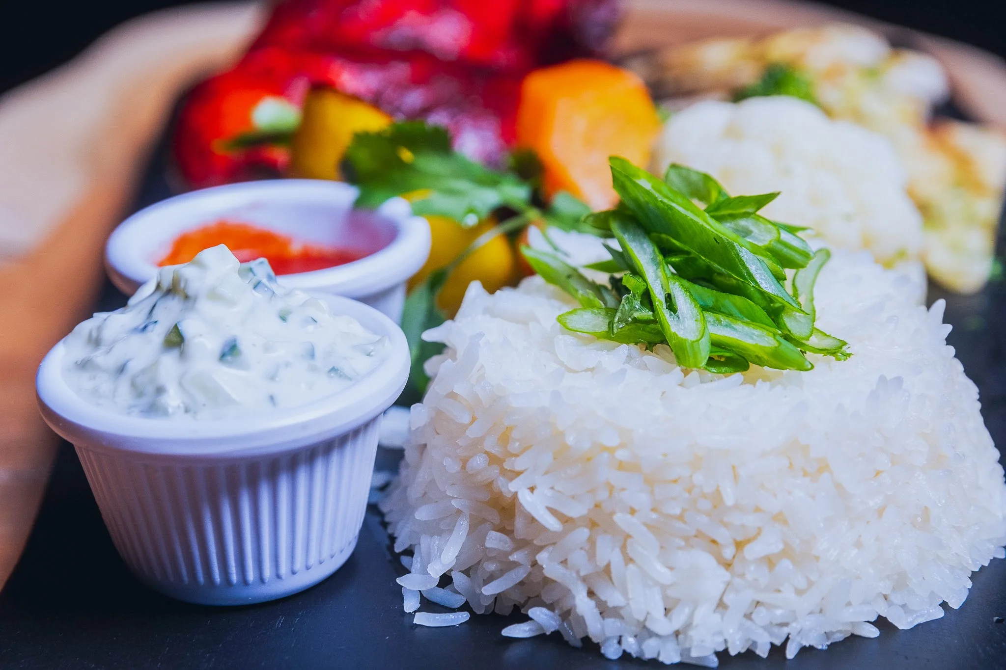 Best professional food photography in New York City (NYC), white rice garnish, green onions with assorted sauce, and roasted vegetable sides. Shot by Lumumba David from David Media Group