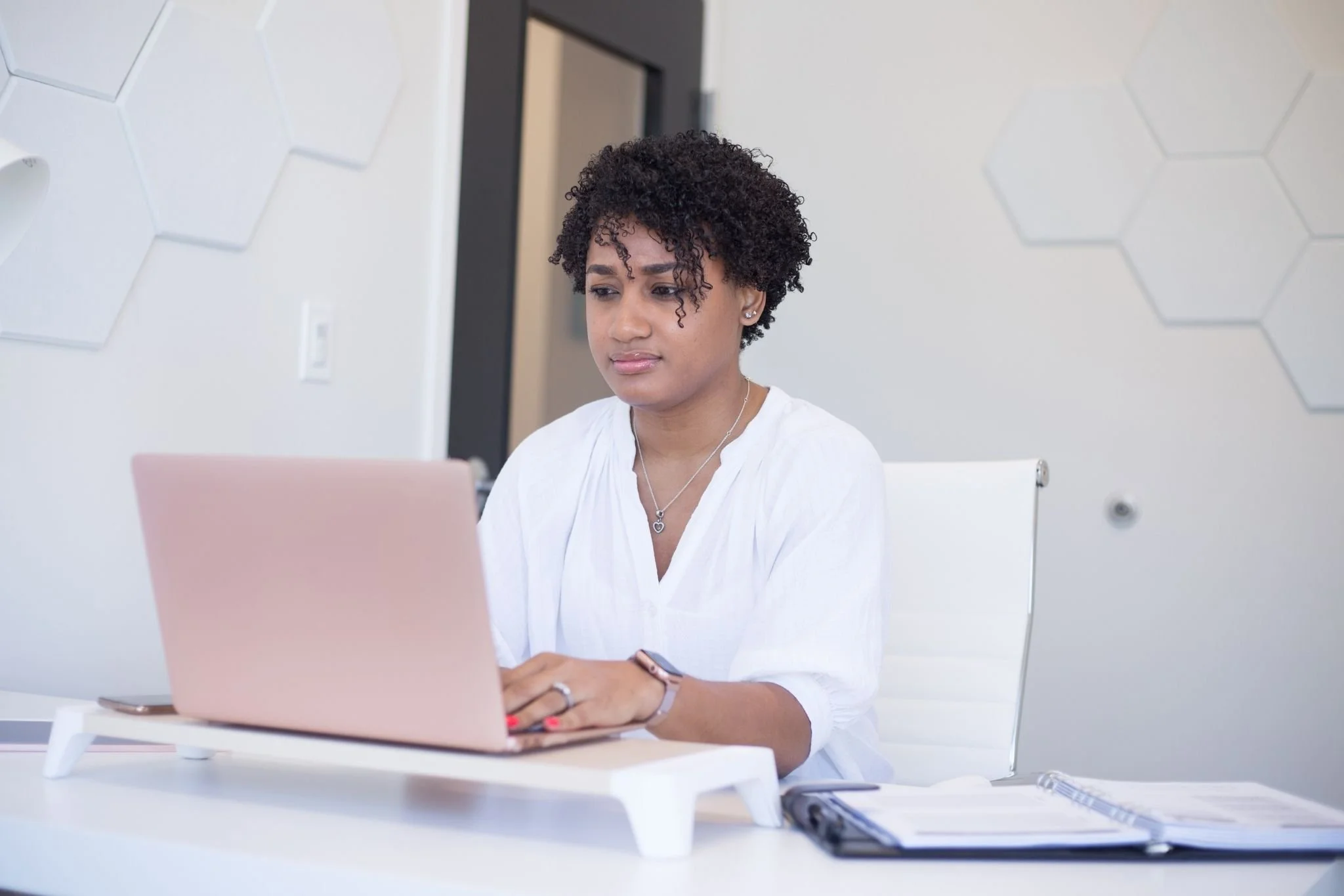 young woman working at pink computer
