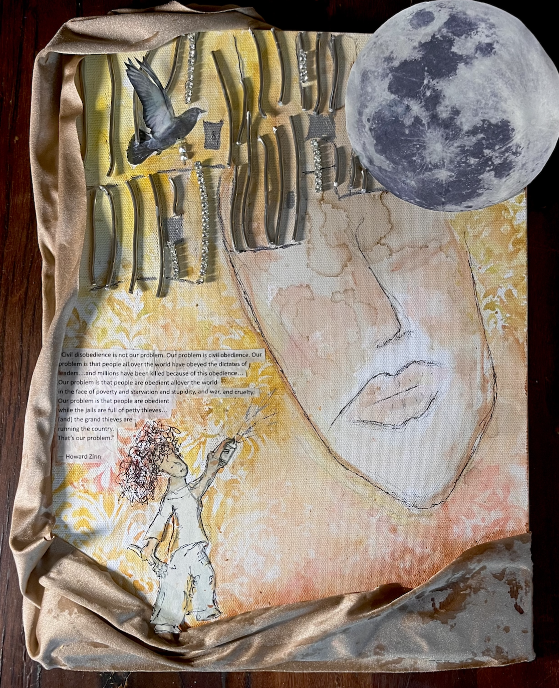 Mixed media artwork featuring a large graphite sketch of a person's face with lips, a mounted full moon, a drawing of a child with curly hair holding a stick, a white and yellow patterned background, a quote by Howard Zinn about civil disobedience, and an artificial bird flying near metallic sculptural objects.
