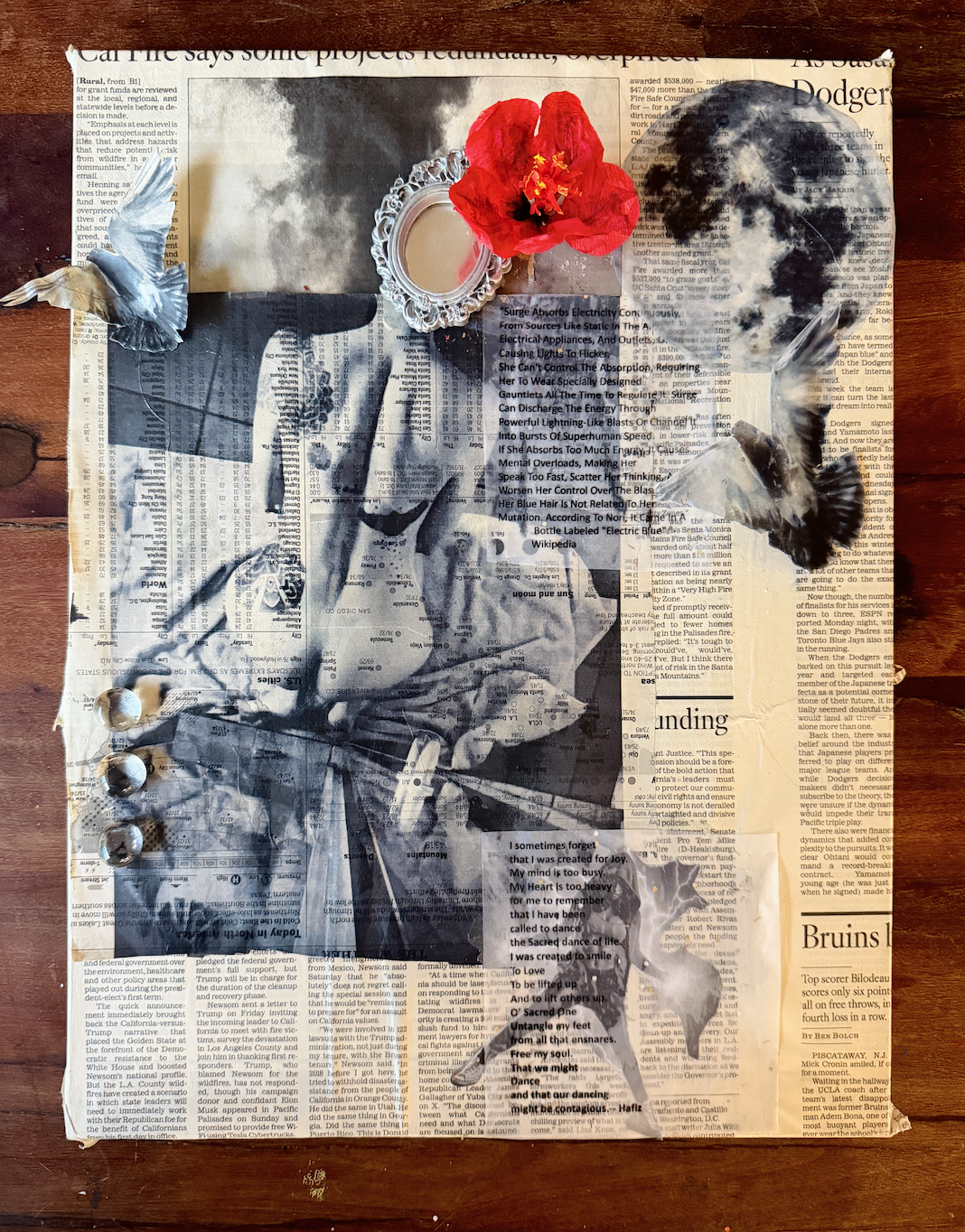 Mixed media art piece on a newspaper background featuring a black and white portrait of a woman, topped with a real red flower, a seashell, feathers, and tacks, with an abstract lightning bolt and handwritten text in the foreground.