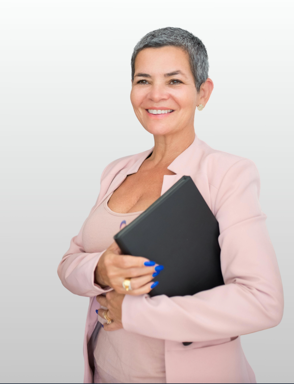 beautiful businesswoman in a pink suit, holding a binder, with short, silver and black hair, and a warm smile.