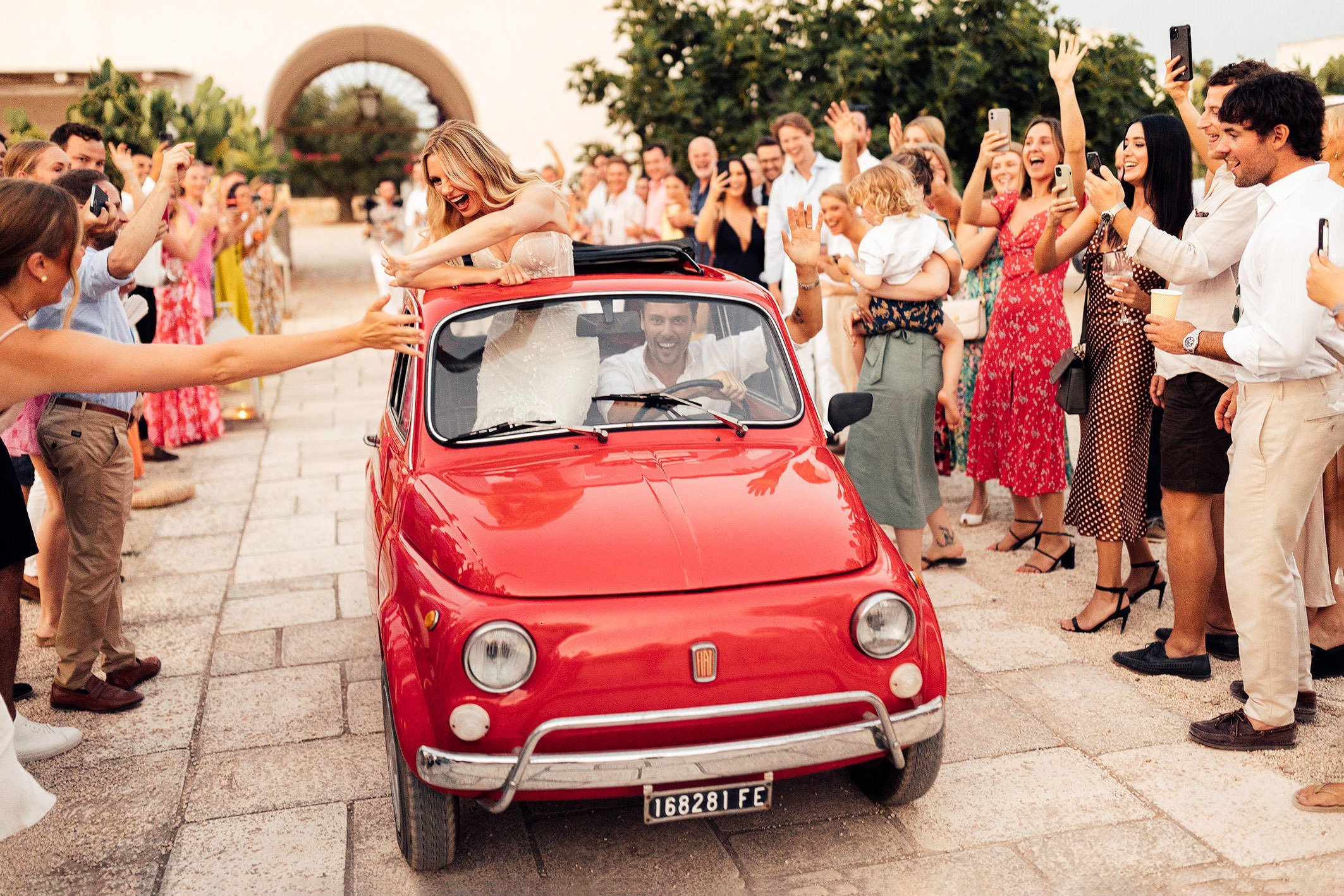 couple arrive in vintage red fiat at Masseria Potenti wedding