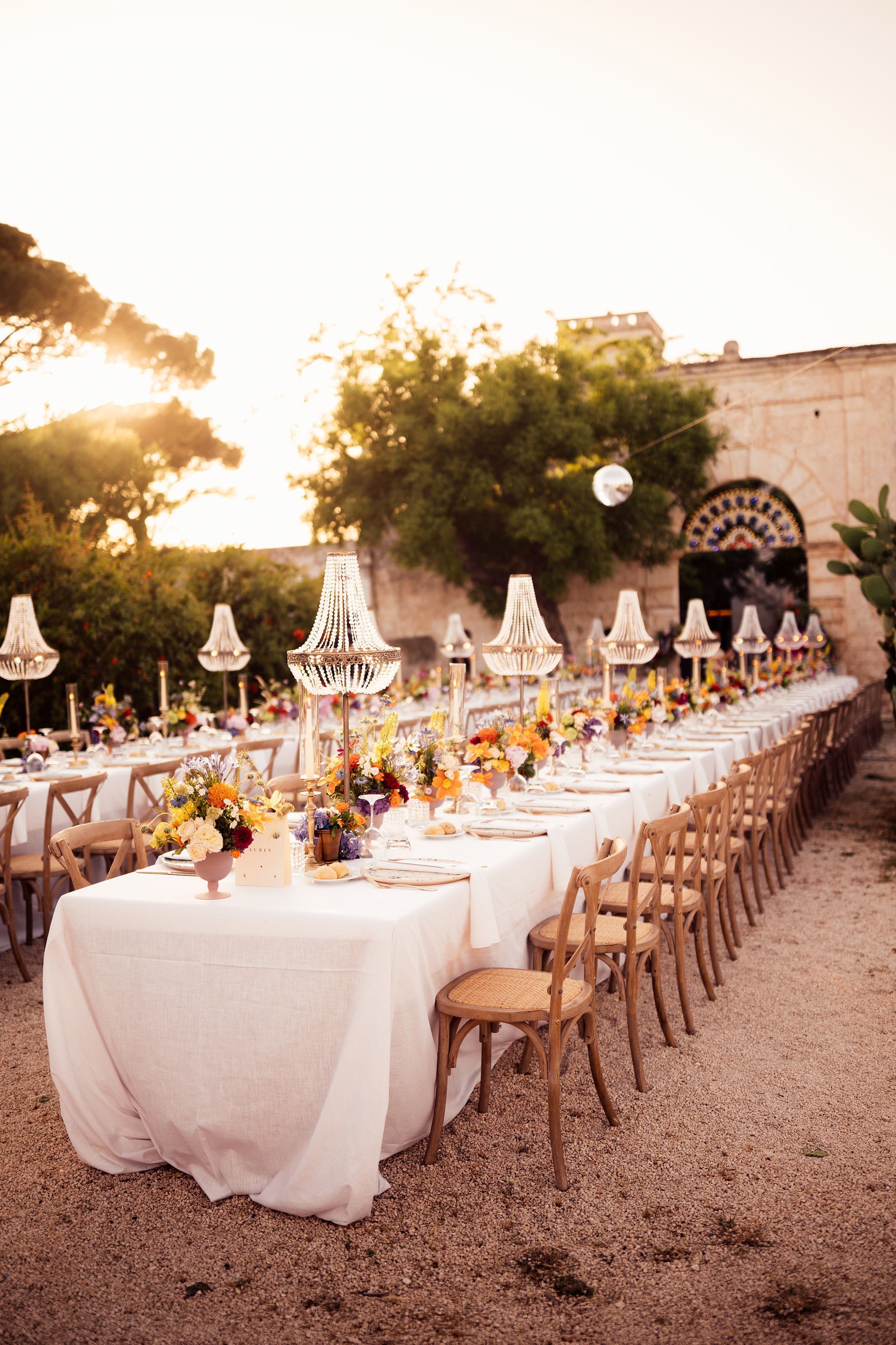 Puglia wedding table scape with colourful florals and chandelier installation 