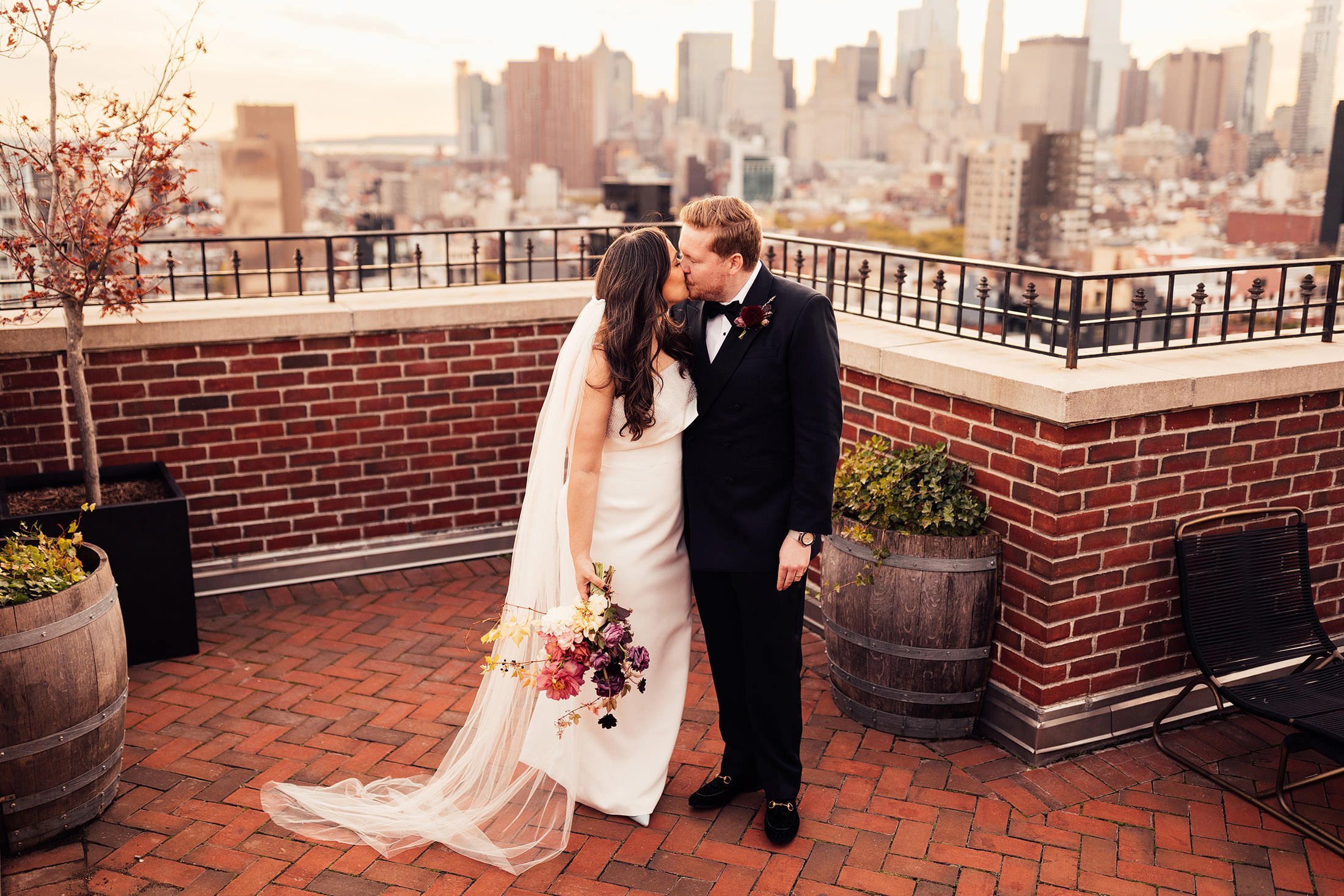 couple kiss on New York City rooftop at the ludlow hotel