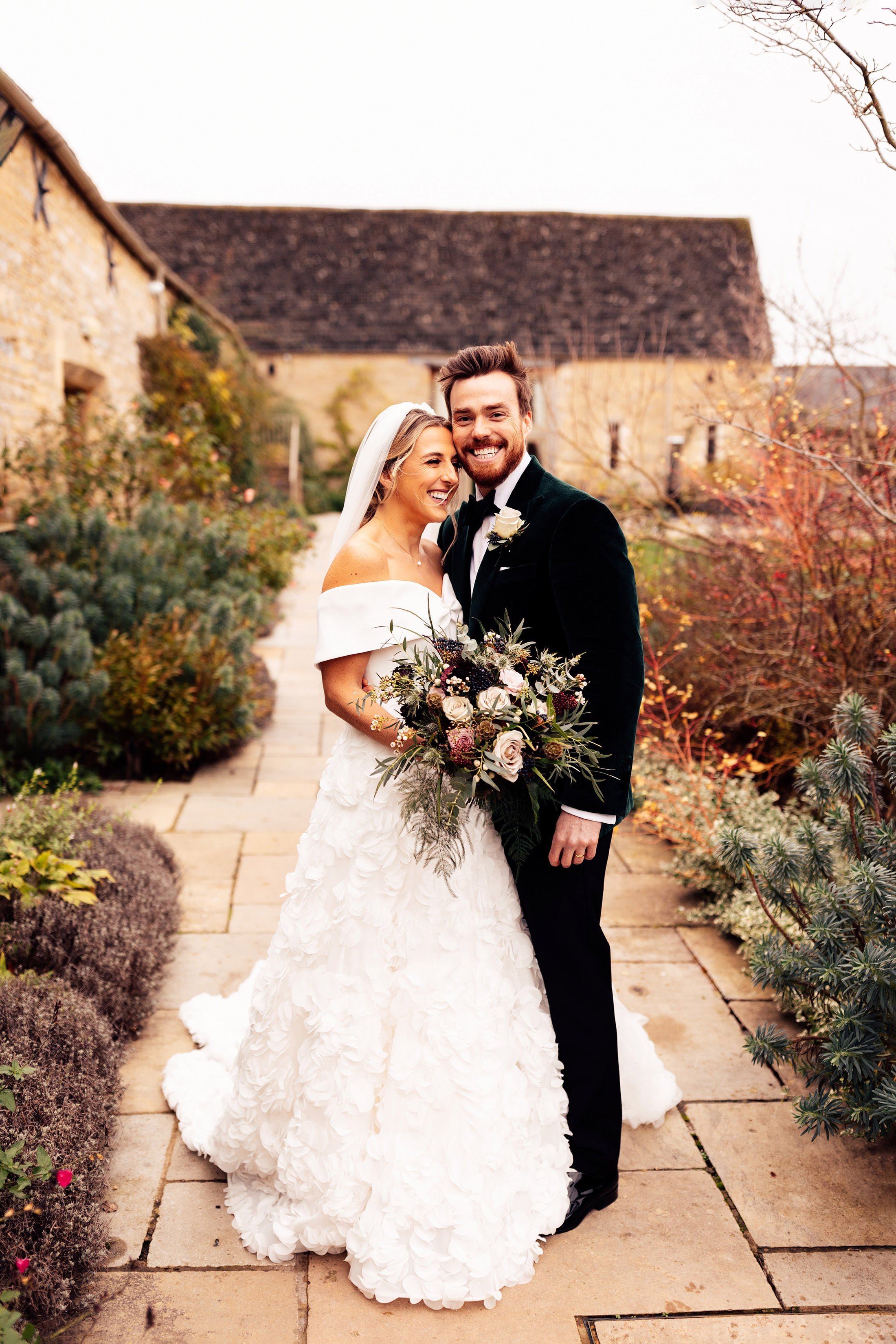 couple portrait outside Caswell house with bride in sassi holford dress