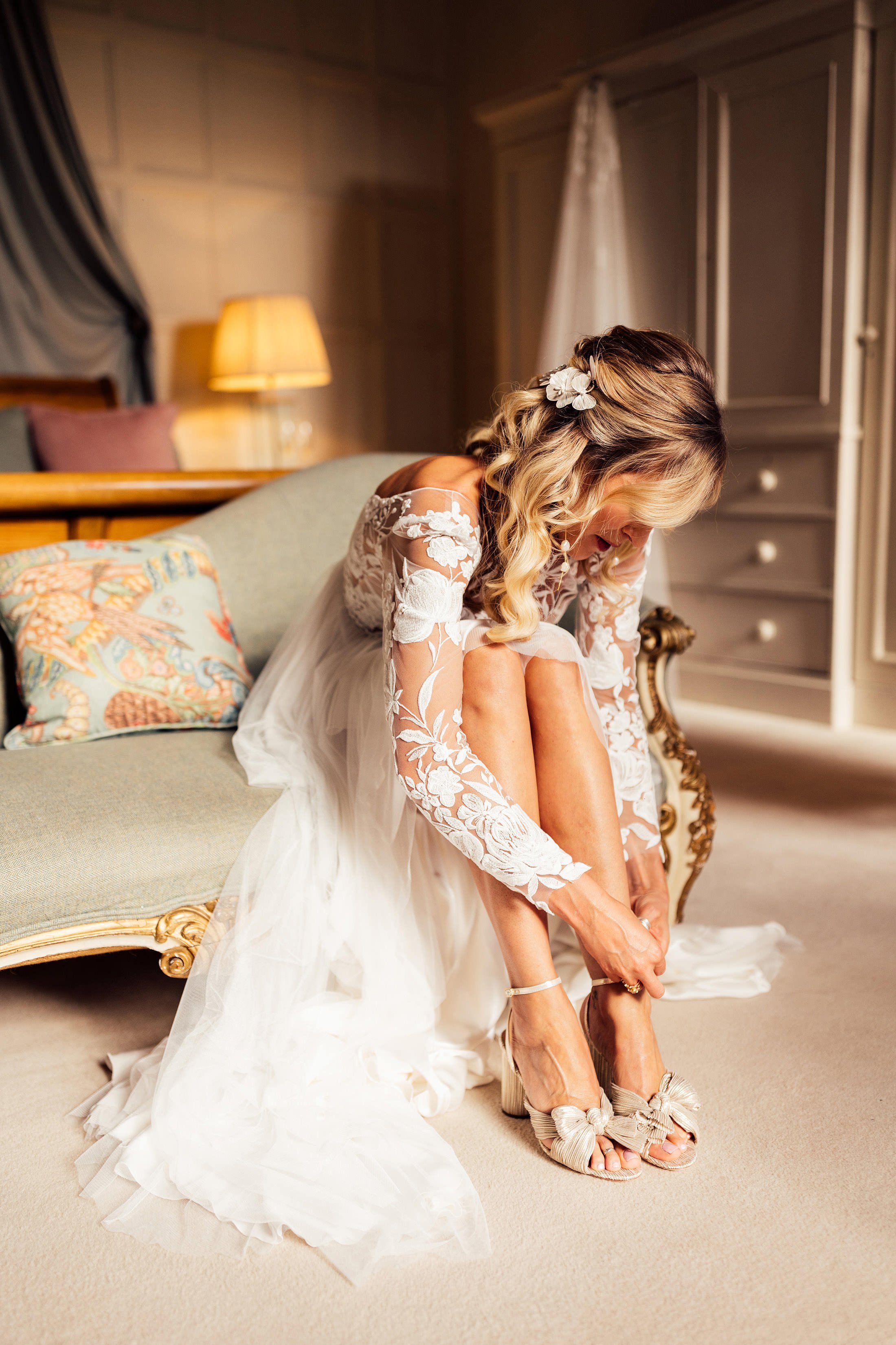 bride getting ready at Elmore court putting gold shoes on